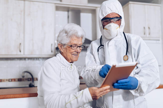 Медичний фахівець, що пояснює рецепт пацієнта під час карантину — стокове фото