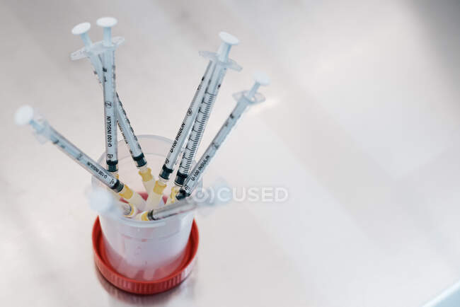 From above bunch of syringes with hormonal drugs placed in container on table in lab of fertility clinic — Stock Photo