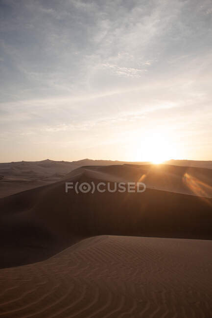 Picturesque landscape of sandy dunes of endless desert terrain in sunset in Peru — Stock Photo