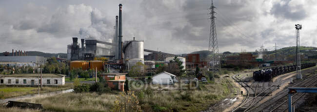 Panoramic view of industrial area with buildings and workshops located near railway line in Asturias — Stock Photo