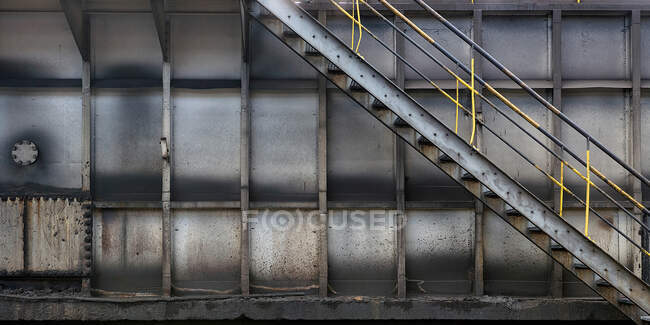 Metalltreppe in einer geräumigen Industriehalle in der Nähe einer schäbigen Metallwand in einem modernen Industriegebäude in Asturien — Stockfoto