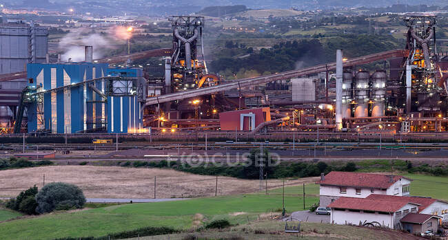 Blick auf moderne Industriebauten mit Rohren und Straße entlang der Werkstätten in Aviles — Stockfoto