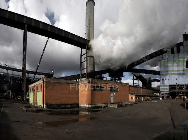Промислові будівлі з трубою і металевими конструкціями, розташовані на сучасному промисловому заводі в Астурії. — стокове фото