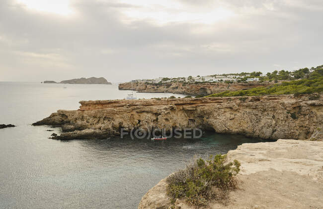 Picturesque view of rocky seashore with cliffs and sailboats — Stock Photo