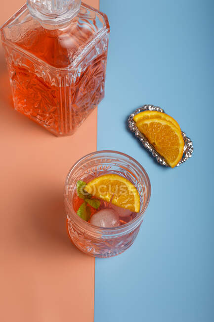 Cocktail laranja frio fresco em jarro e copo de vidro com cubos de gelo — Fotografia de Stock