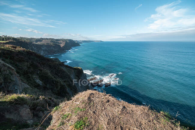 Pintoresco paisaje de la costa del mar con rocas que se elevan sobre el agua contra el hermoso cielo claro - foto de stock