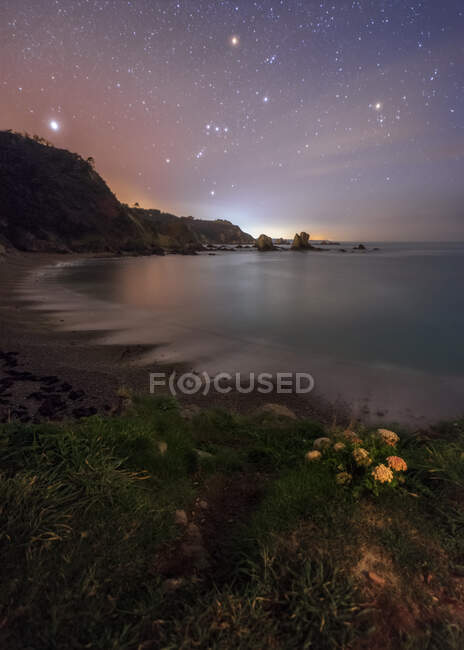 Night landscape of rocky beach with starry sky — Stock Photo