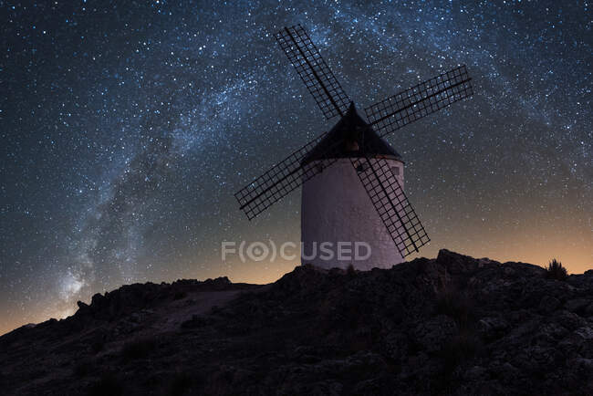 Moulin à vent sur colline avec ciel étoilé sur fond — Photo de stock