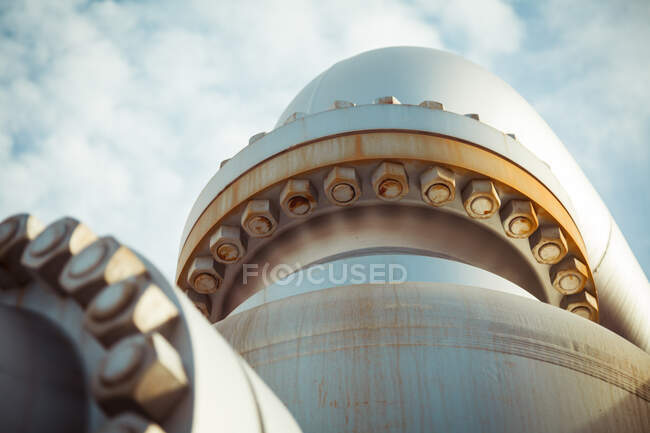 From below of rusty flanged joints of pipe bolting together with metal nuts at plant — Stock Photo