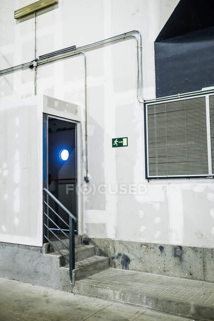 Facade of factory with plasterboard walls and exit with modern glass door — Stock Photo