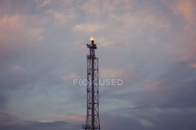 Von unten die Flamme, die aus dem Rohr des Fackelstapels in der Erdölraffinerie freigesetzt wird — Stockfoto
