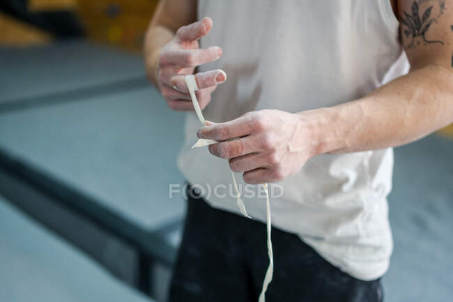 From above of anonymous male athlete in active wear standing and taping fingers in talcum powder in gym — Stock Photo