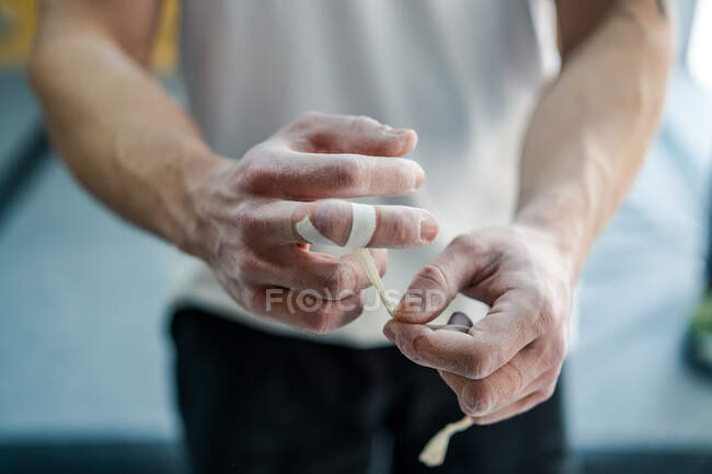 D'en haut de l'athlète masculin anonyme en tenue active debout et les doigts d'enregistrement dans la poudre de talc dans la salle de gym — Photo de stock