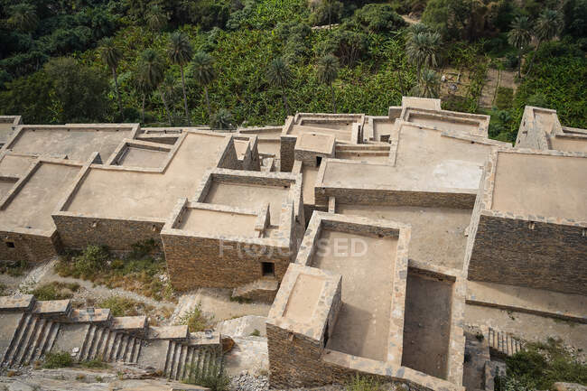 Dall'alto di tetti lontani di edifici in pietra invecchiati dell'antico villaggio di marmo vicino alla foresta tropicale verde di Al Bahah in Arabia Saudita — Foto stock