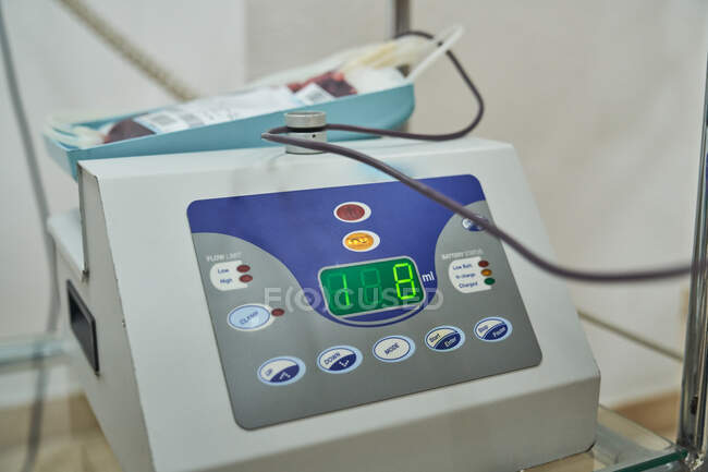 Primer plano de la máquina mezcladora de recolección de sangre que indica el volumen de sangre del donante en el laboratorio médico - foto de stock