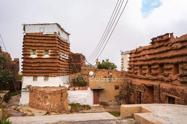 Внешний вид жилого дома с традиционными орнаментами на фасаде расположен недалеко от человека в серый день на улице города — стоковое фото