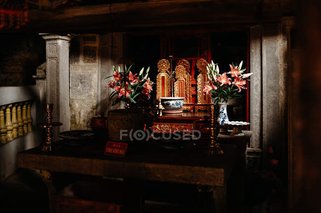 Traditioneller reich verzierter Tisch mit Kerzenständern und Süßwasser in einer Schüssel für den Gottesdienst in einem Tempel in Vietnam — Stockfoto