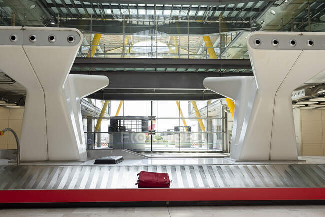 Международный аэропорт с зоной претензий на металлический багаж и массивными конструкциями в футуристическом стиле, освещенными солнечным светом — стоковое фото