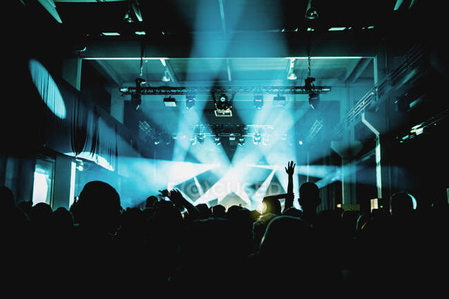 Силуети людей на фоні освітлення сцени світла під час виконання музики — стокове фото