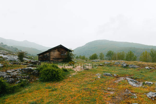 Maison isolée dans la vallée montagneuse par temps couvert — Photo de stock