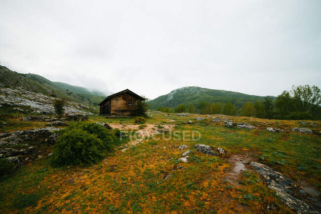 Casa solitária em vale montanhoso em dia nublado — Fotografia de Stock