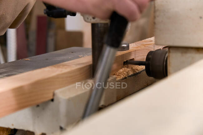 Crop man using special electric machine while working in contemporary workshop — Stock Photo