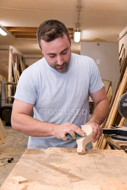 Artisan polimento detalhe de madeira usando lixa na oficina de carpintaria — Fotografia de Stock