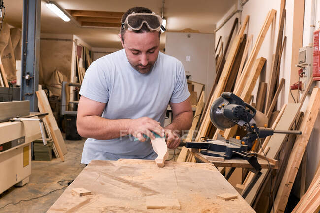 Handwerker polieren Holzdetails mit Schmirgelpapier in Tischlerei — Stockfoto