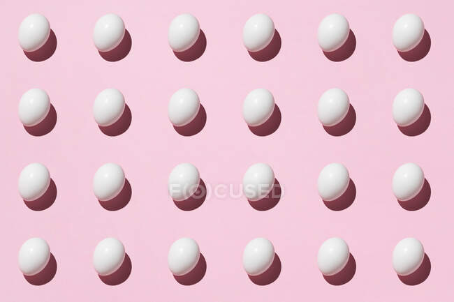 Nahtloser Hintergrund mit weißen Eiern auf rosa — Stockfoto