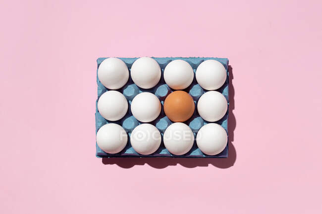 Uova in vassoio di carta su superficie rosa — Foto stock