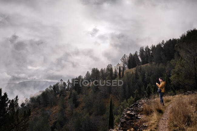 Escursionista irriconoscibile in piedi sul prato di campagna e vista ammirabile — Foto stock