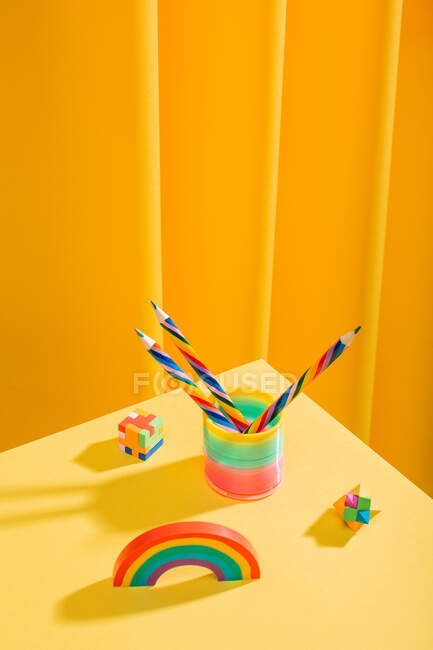 Escritorio amarillo mínimo y colorido con lápices y borradores sofisticados - foto de stock