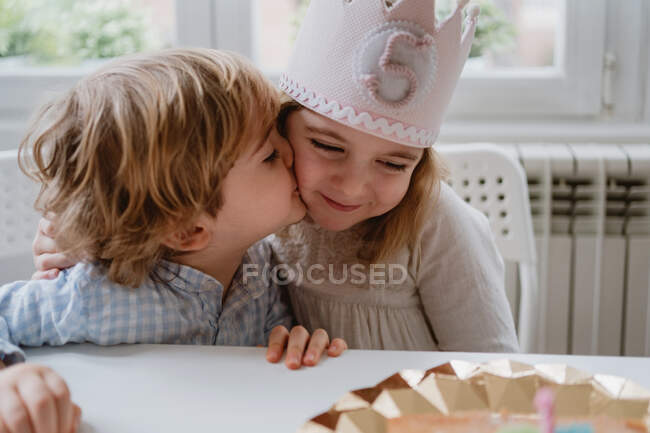 Menino beijando sua irmã em seu aniversário — Fotografia de Stock