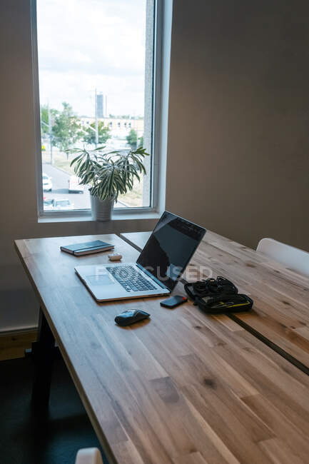 Netbook e mouse posizionati su tavolo in legno con notebook e auricolari wireless in uno spazio di lavoro creativo — Foto stock