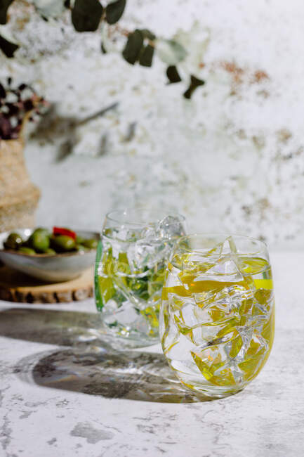 Bicchieri di cocktail in luce solare brillante sulla superficie di cemento — Foto stock
