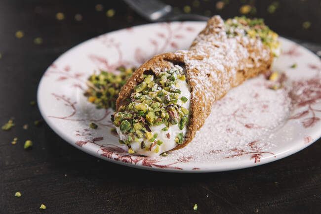 Homemade Sicilian Cannoli with ricotta filling garnished with pistachios and sugar powder — Stock Photo