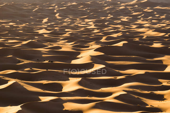 Вид с беспилотника на живописные пейзажи пустыни с песчаными дюнами в солнечный день в Марокко — стоковое фото