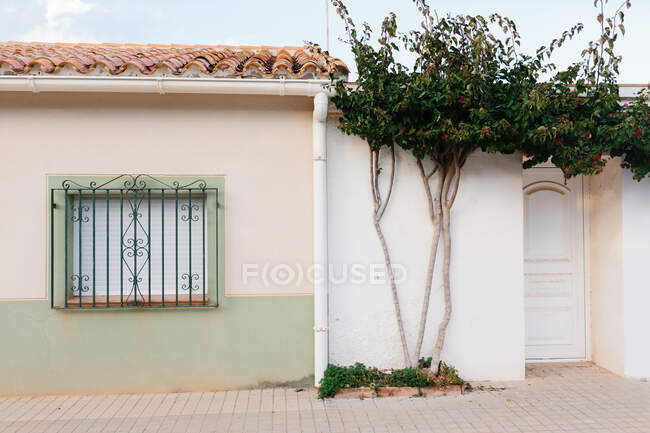 Kleines Wohnhaus aus Stein mit Eingang, tagsüber mit blühenden Bäumen geschmückt — Stockfoto