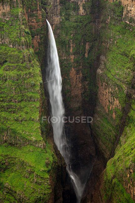 Desde arriba de impresionantes paisajes de gran cascada de Jinbar con un poderoso arroyo que fluye por el barranco rocoso - foto de stock