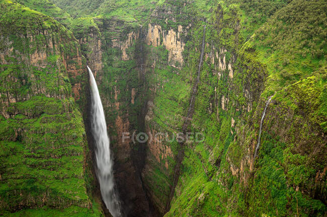 Desde arriba de impresionantes paisajes de gran cascada de Jinbar con un poderoso arroyo que fluye por el barranco rocoso - foto de stock