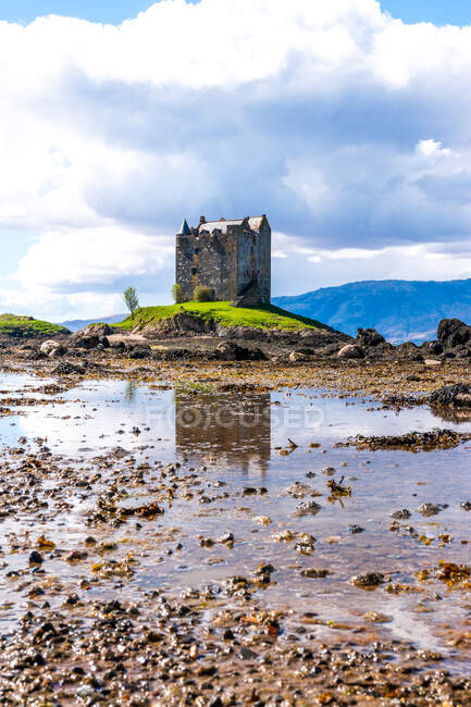 Paisagem de primavera brilhante com castelo de pedra medieval localizado na colina perto do rio em vale verde em Highlands escoceses em dia ensolarado com céu nublado — Fotografia de Stock