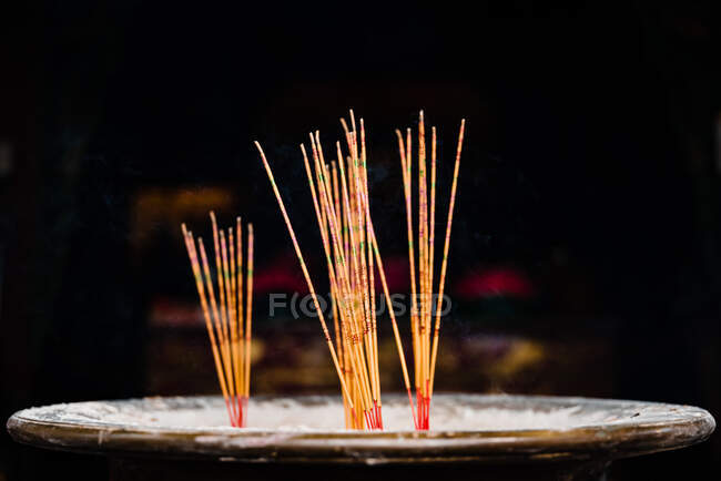 Empilement non éclairé de bâtonnets d'encens placés au centre d'un bol de pierre rond religieux dans le temple de Hong Kong — Photo de stock