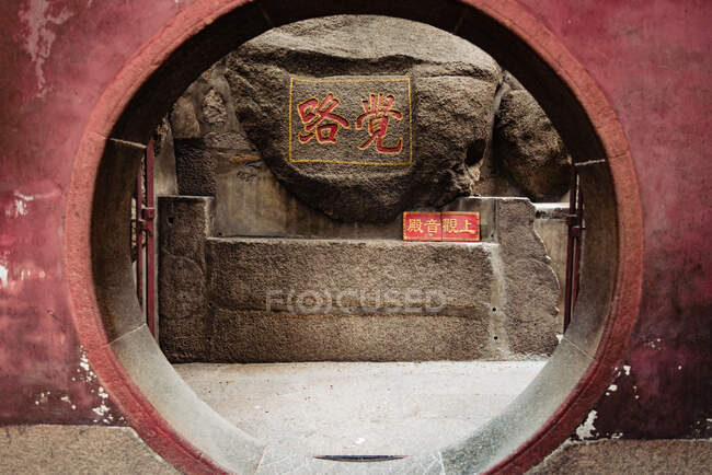 Porta da lua de entrada em parede pintada de vermelho de um templo Ma em Macau — Fotografia de Stock