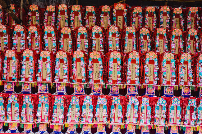 Rows of colorful decorative figurines with hieroglyphs placed on shelves in Hong Kong temple — Stock Photo