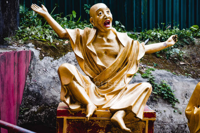 Caída estatua de Buda de oro en la silla en el jardín de luz de los Diez Mil Budas en Hong Kong - foto de stock