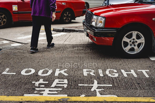 From above of Look right inscription with hieroglyphic translation on pavement of city street with pedestrian crosswalk in Hong Kong — Stock Photo