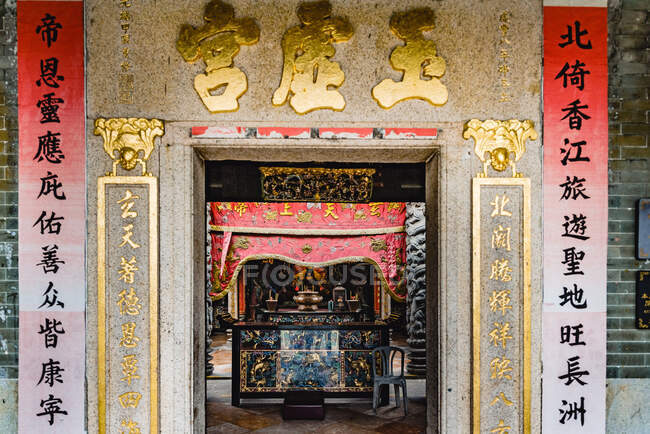 Antiguo tazón de piedra con varillas de incienso ahumado en la entrada del majestuoso templo Yuk Hui en Hong Kong - foto de stock