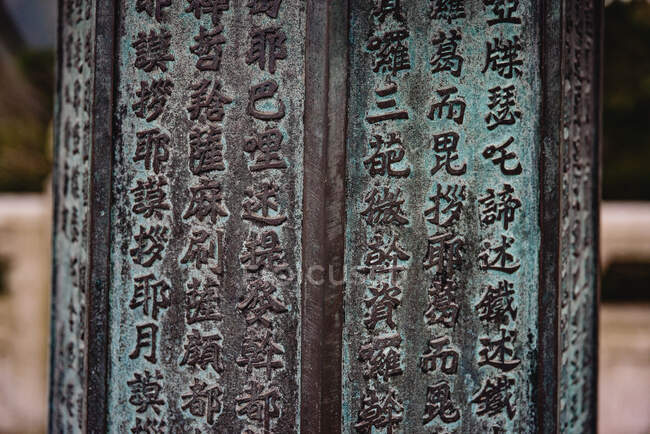Closeup of shabby surface of pillar with rows of Chinese hieroglyphs in Hong Kong — Stock Photo