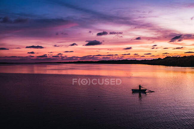 Silhouette de la personne sur le bateau dans la baie tranquille contre le coucher du soleil merveilleux ciel au Mexique — Photo de stock