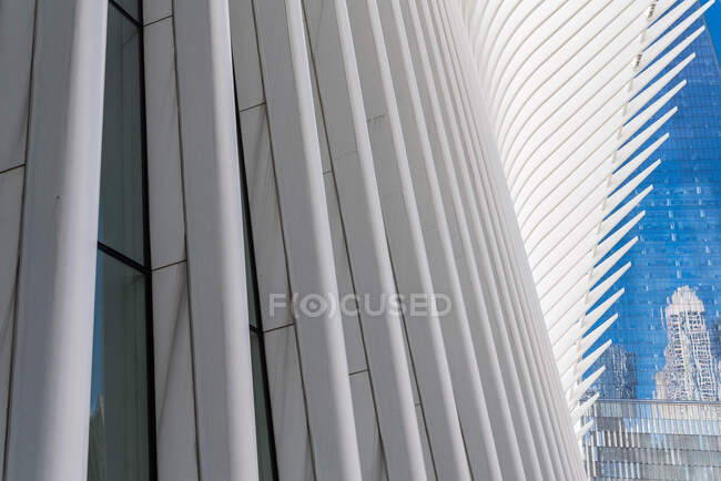 From below of contemporary skyscrapers with glass mirrored walls and futuristic construction on background of blue sky — Stock Photo